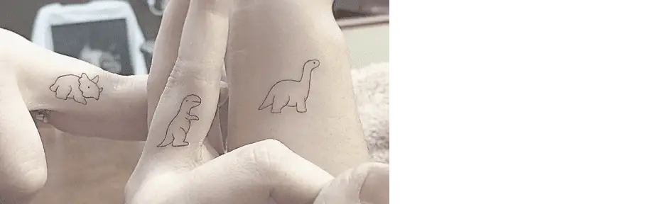 three tattoos of dinosaurs on three peoples fingers