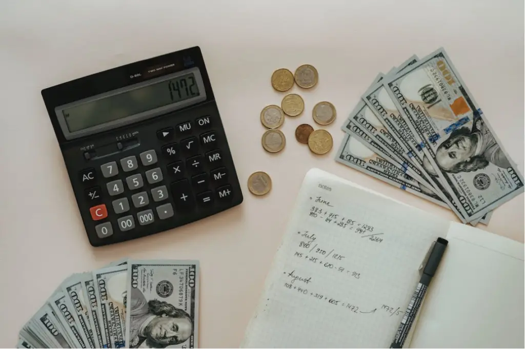 money, calculator, coins, and pen on desk