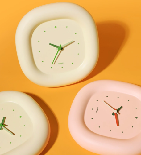 white and pink clock in orange background