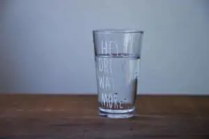 Cup of water with the words "hey drink water more"